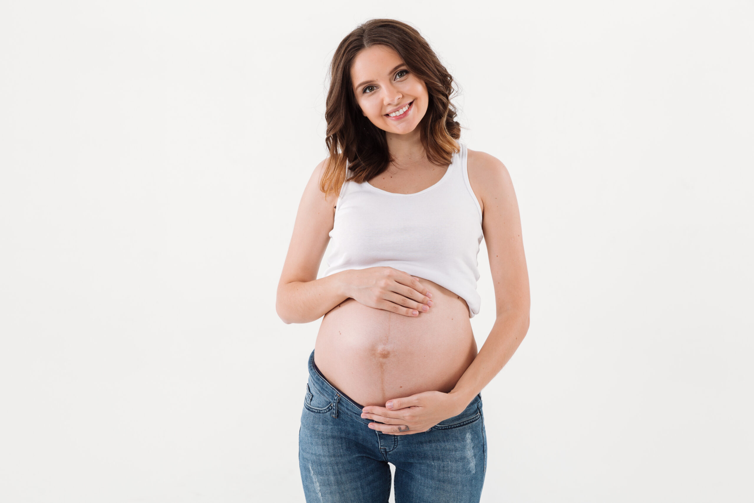 Pregnant woman standing isolated over white backgrond